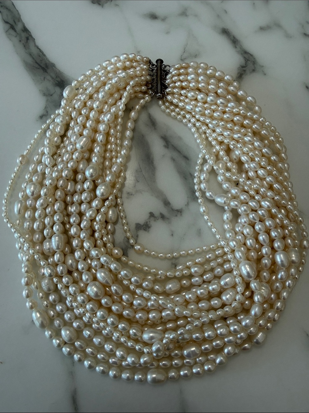 Multi-strand necklace of freshwater pearls with silver side clasp